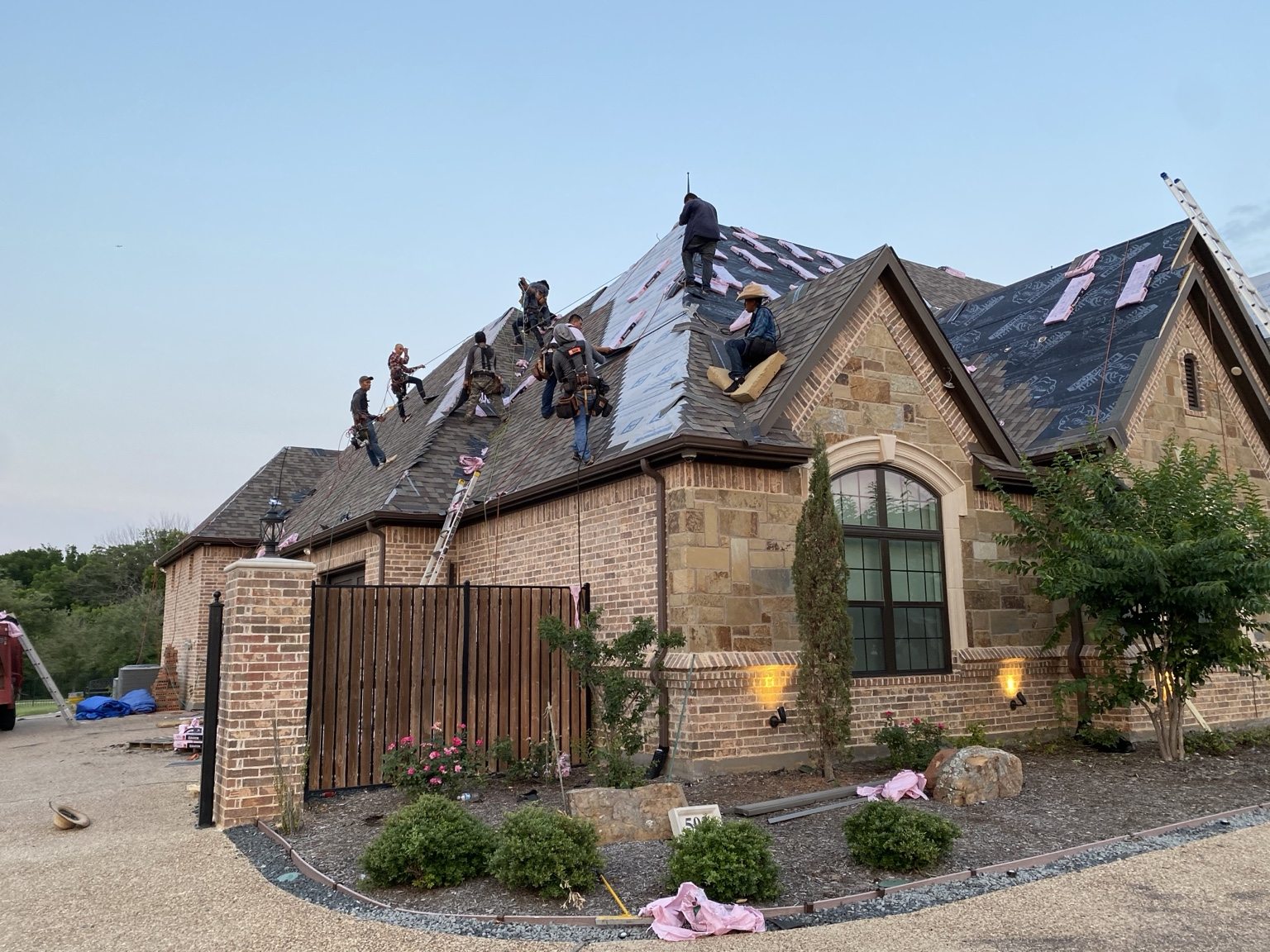 Roofing crew installing shingles